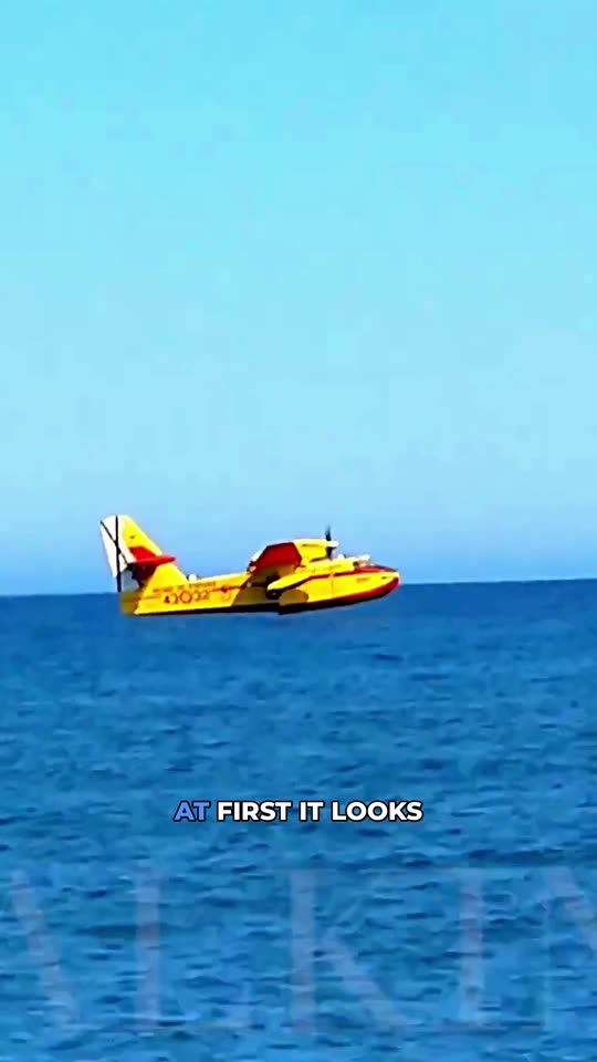 Vertical Short: a firefighting aircraft skimming the sea surface to scoop water, with a burned-in English caption.